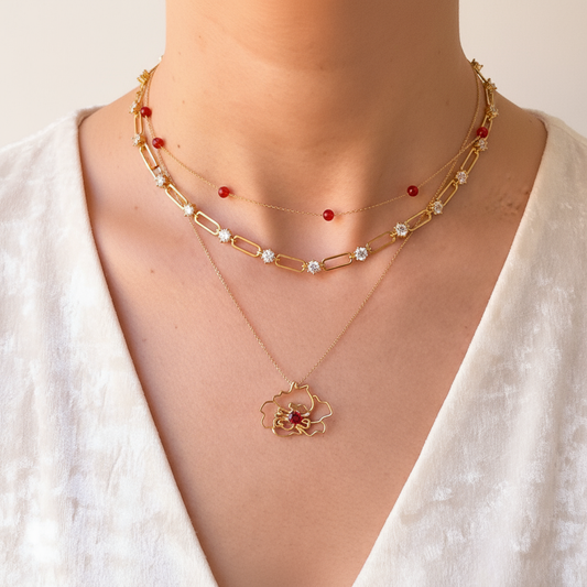 Woman wearing solid gold Palestine Poppy Flower pendant handcrafted by SOIL Jewelry